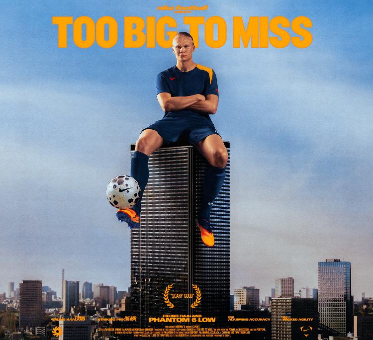 Erling Haaland sitting on top of a buildling balancing a football on his foot.