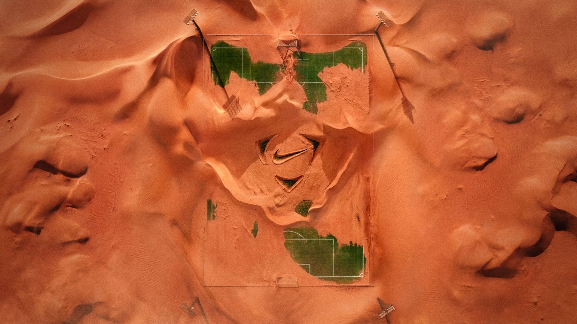 Nike Football etched in a sand covered pitch.
